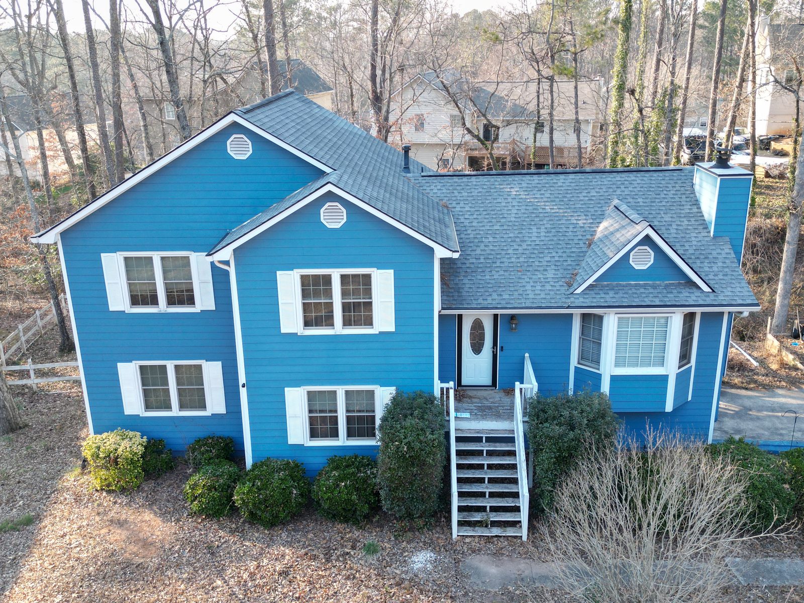 Elevated exterior photo of a blue two-story house for a real-estate listing