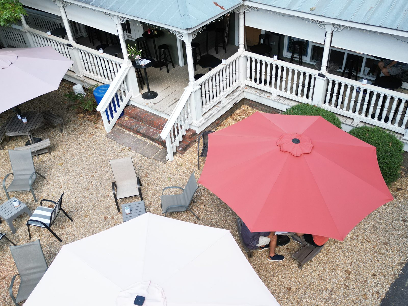 A restaurant patio set with red and white umbrellas, delivered in a branded client gallery